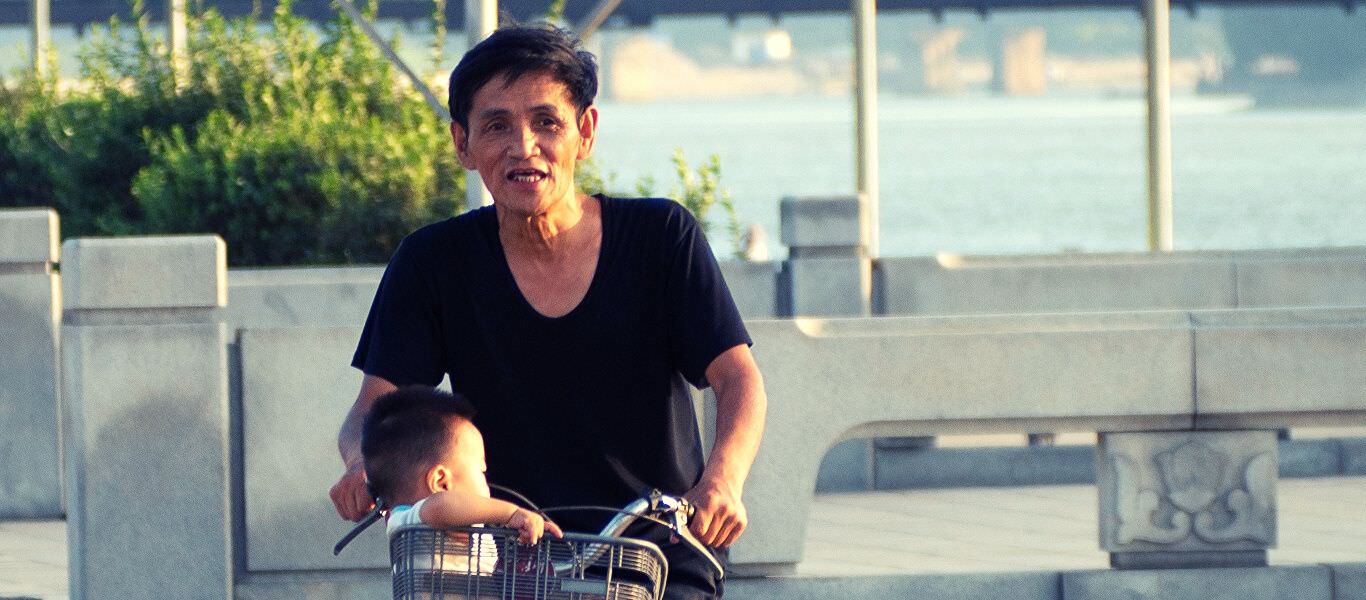 Grandfather in North Korea cycling with grandson. Tour arranged by KTG Travel