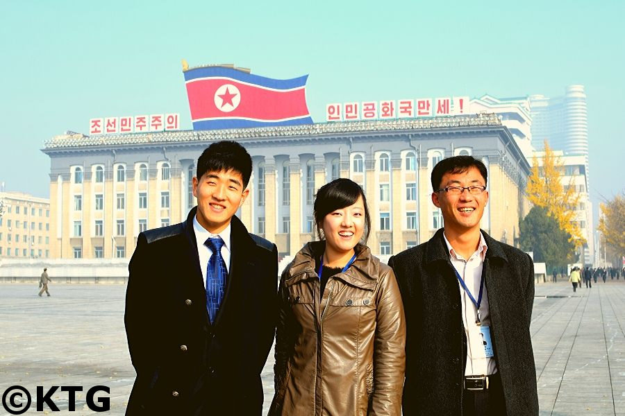 Los guías coreanos Kim Jong Hwa y el Sr. Kang posan junto a un estudiante de la Universidad Kim Il Sung en la Plaza Kim Il Sung en el mismísimo centro de Pyongyang