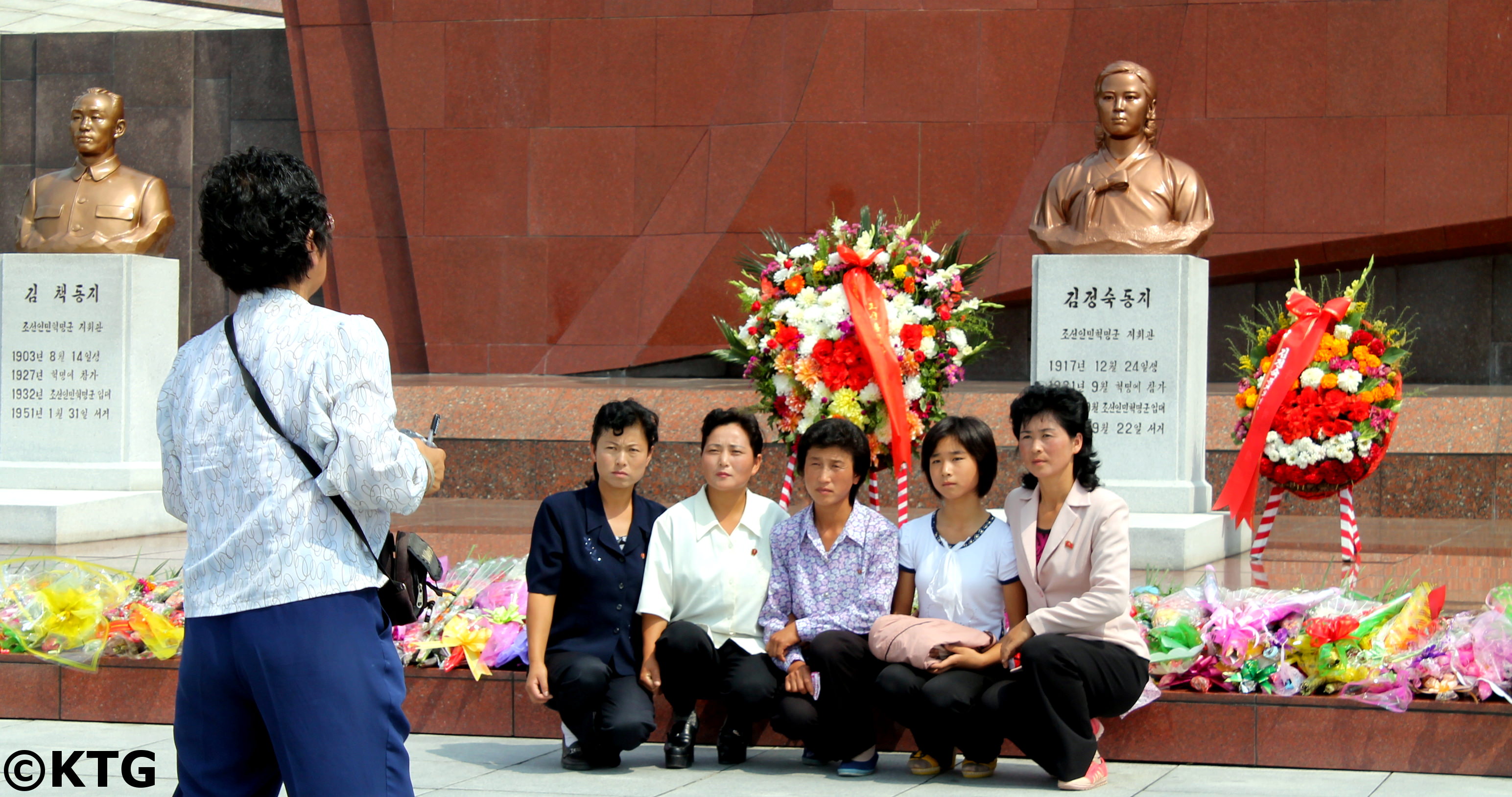 Una familia norcoreana se saca una foto en frente del busto de bronze de la Camarada Kim Jong Suk en el Cementerio de los Mártires Revolucionarios en Pyongyang en de Corea del Norte