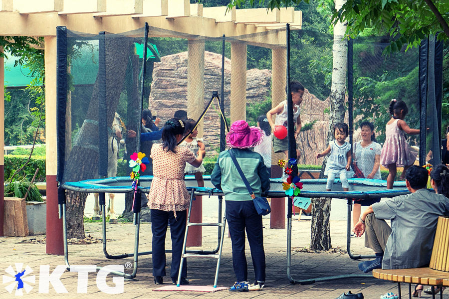 Des enfants s'amusent au zoo de Corée centrale à Pyongyang. Vous pouvez monter en calèche et faire une visite du zoo. Photographie prise par KTG Tours.