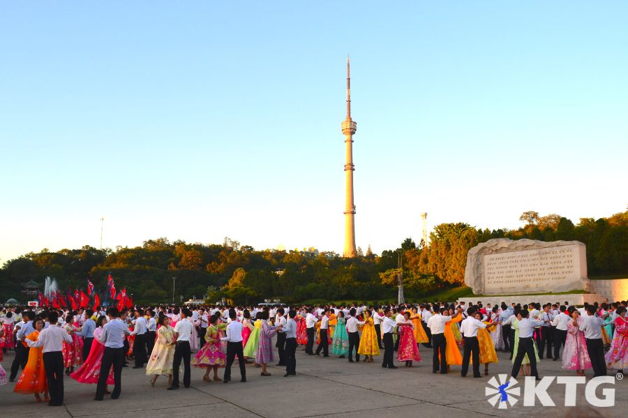 Mass Dances on National Day outside Moranbong Park in Pyongyang capital of North Korea, the DPRK. The Pyongyang Broadcasting Tower can be seen in the backgroud. Picture taken by KTG Tours