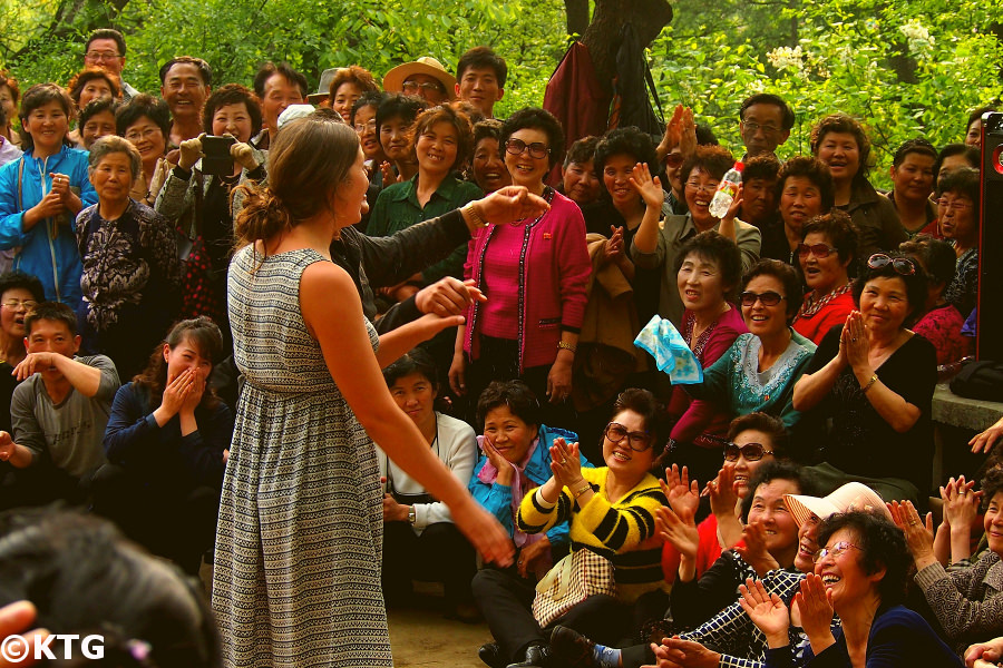 Viajero de KTG Tours bailando con norcoreanos el Primero de Mayo en el Parque Moran in Pyongyang, capital of Corea del Norte, DPRK