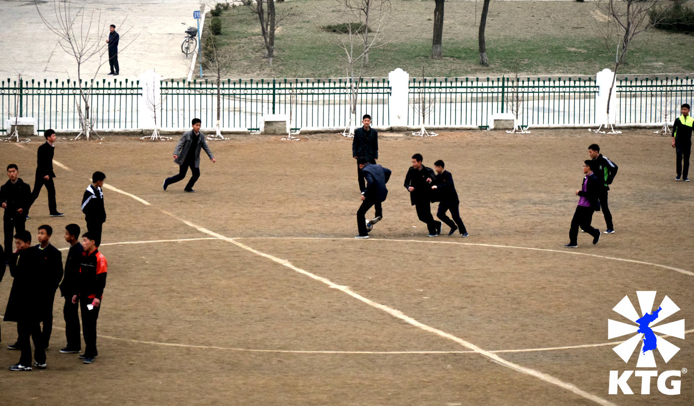 Children playing football (soccer) a middle school playground in Pyongyang, capital of North Korea. Picture taken by KTG Tours