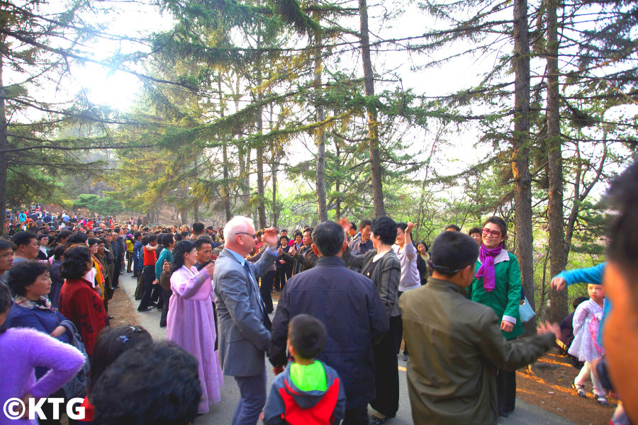 Voyageur KTG dansant avec les habitants de Moran Park à Pyongyang, la capitale de la Corée du Nord. Des milliers d'habitants se rassemblent ici le 25 avril pour manger, boire et danser pour célébrer l'anniversaire du président Kim Il Sung. Photo prise par KTG Tours