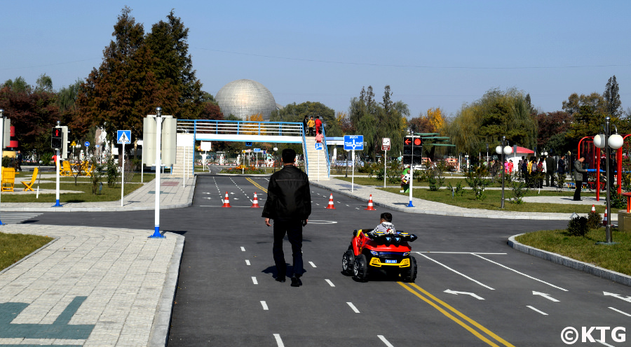 Niño conduciendo un coche de juguete en el Parque Infantil de Tráfico de Pyongyang, Corea del Norte (RPDC)