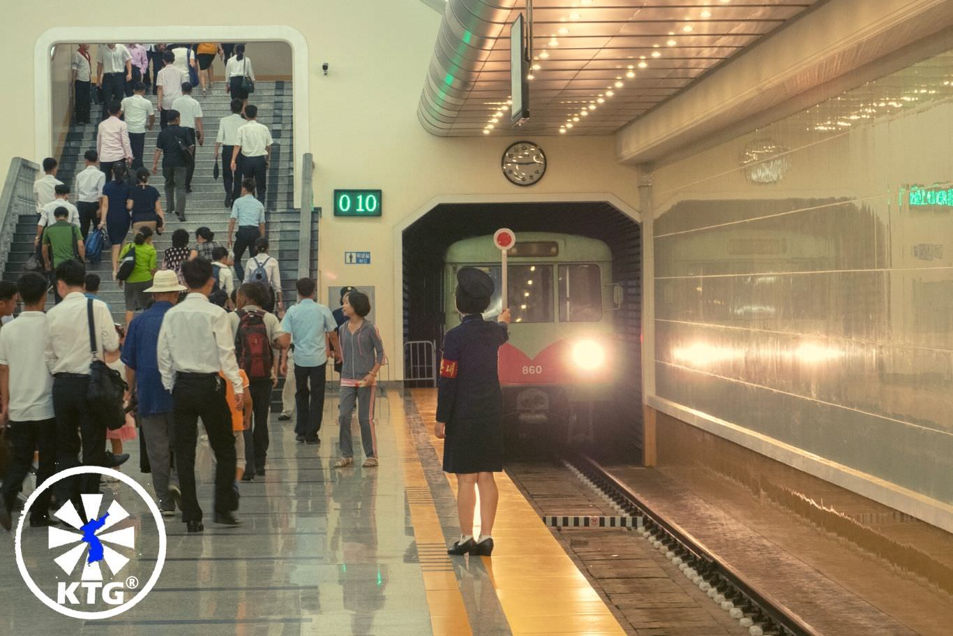 Passengers at a metro stop in Pyongyang, North Korea. Tour arranged by KTG®