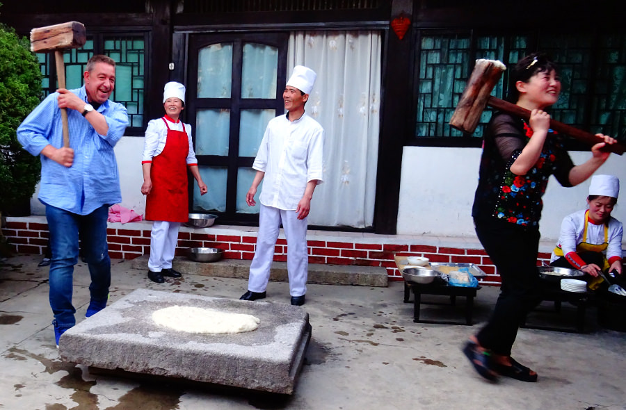 Viajeros preparando pastel de arroz en el hotel tradicional coreano en Kaesong en Corea del Norte (RPDC). Viaje organizado por KTG