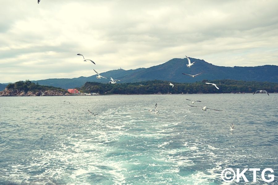 A punto de tomar un paseo en bote en la isla Pipha para ver focas en el mar de Corea del Norte. Rason, en el extremo este de Corea del Norte, RPDC. Viaje organizado por KTG Tours.