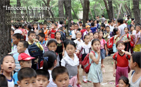 Des enfants nord-coréens semblent perplexes car très peu d'Occidentaux visitent la Corée du Nord. C'est au Songdowon camp d'été de Songdowon