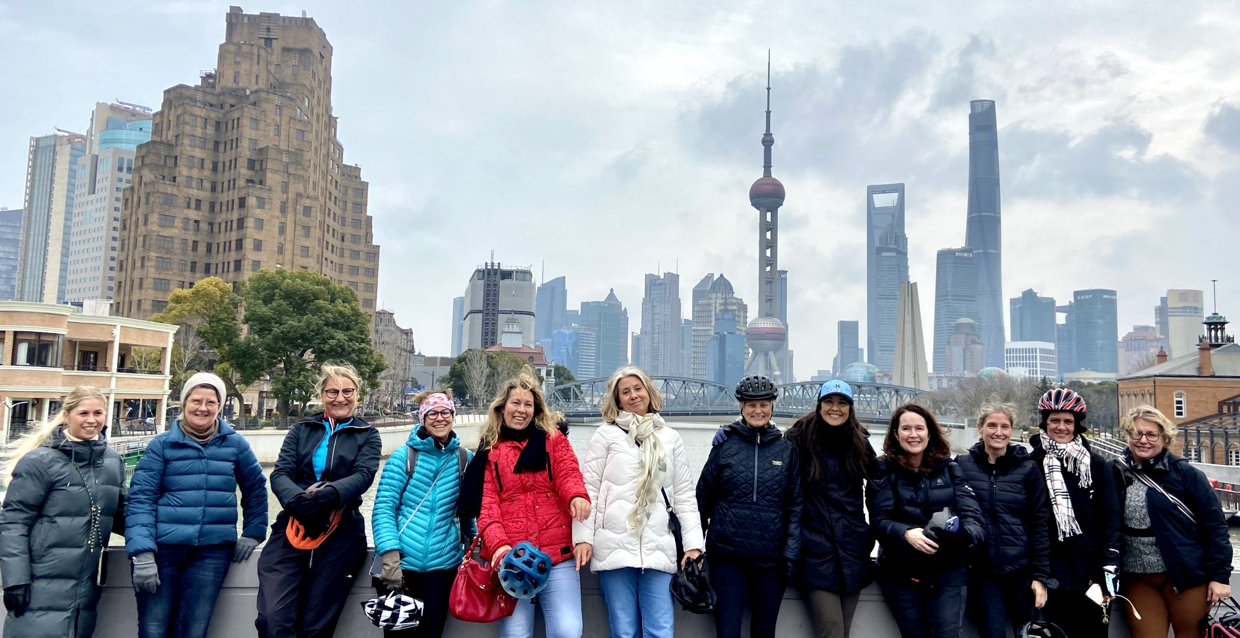 Bike tour along Suzhou Creek, aka Wusong River, in the heart of Shanghai, China. Views of the Luzuijia skyscrapers in the Pudong and Bund districts