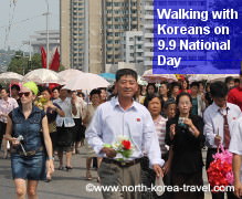 North Koreans walking towards a military parade in Pyongyang with KTG western travellers