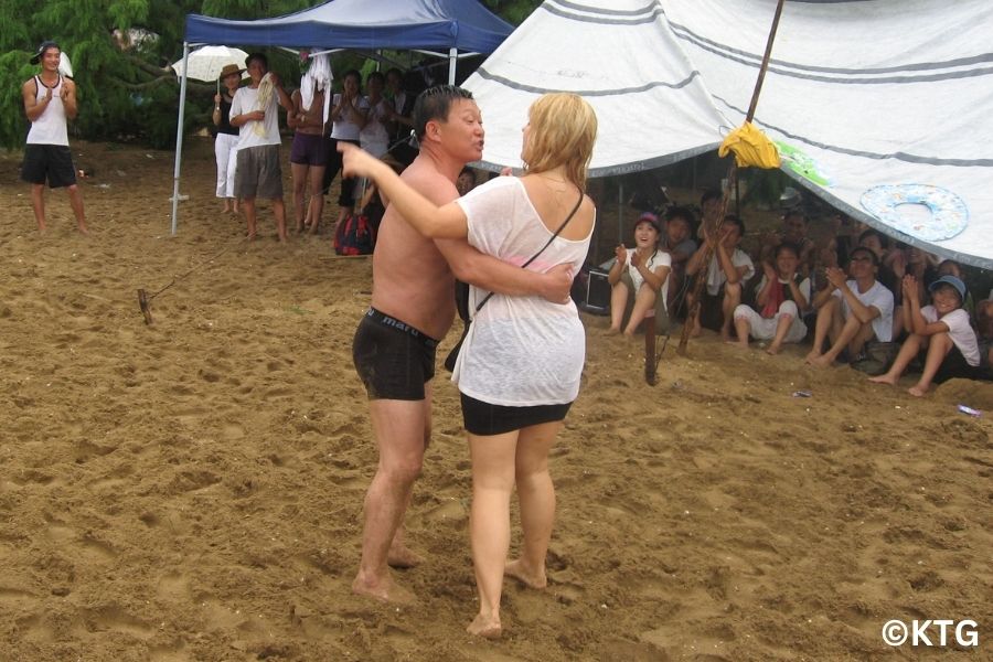 Touriste occidental avec des habitants nord-coréens sur une plage nord-coréenne, la plage de Majon à Hamhung, RPDC. Voyage organisé par KTG Tours.