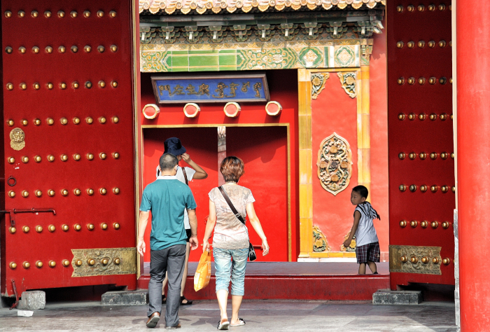 Familia pekinesa entrando en una casa tradicional de Beijing