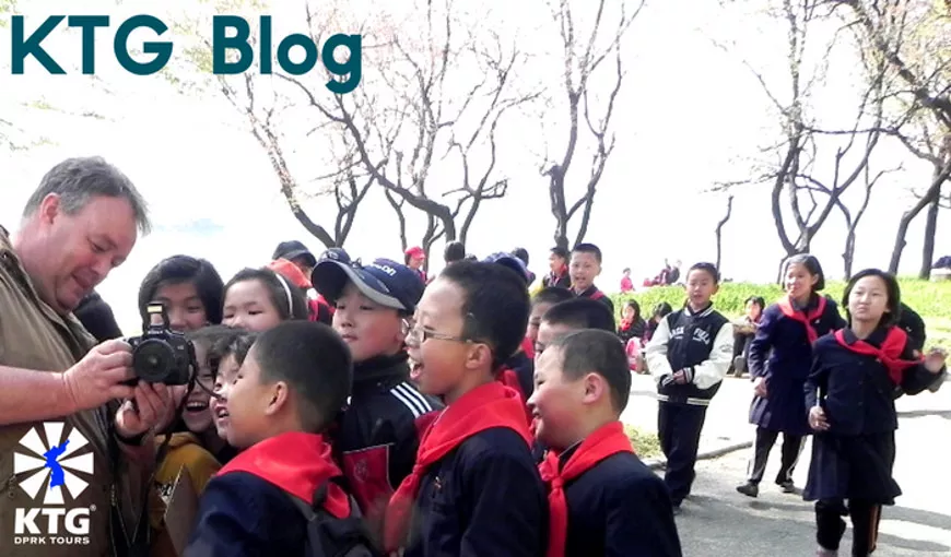 KTG traveller showing North Korean children a picture just taken, Pyongyang, North Korea (DPRK)