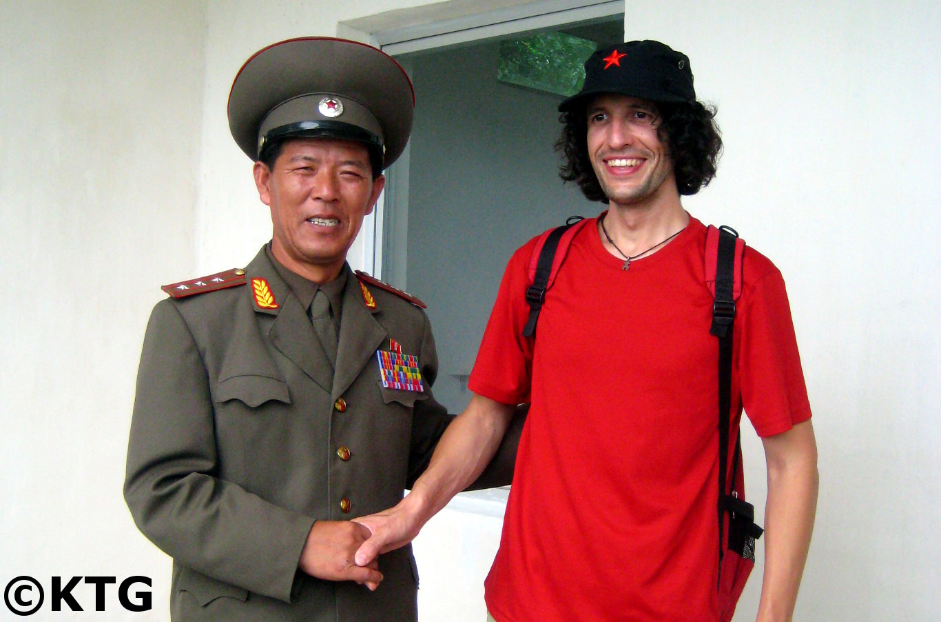 Un voyageur de KTG prend une photo avec un colonel de North Koean. L'officier militaire nord-coréen (RPDC) explique où la Corée du Sud a un mur de béton qui traverse la péninsule coréenne.