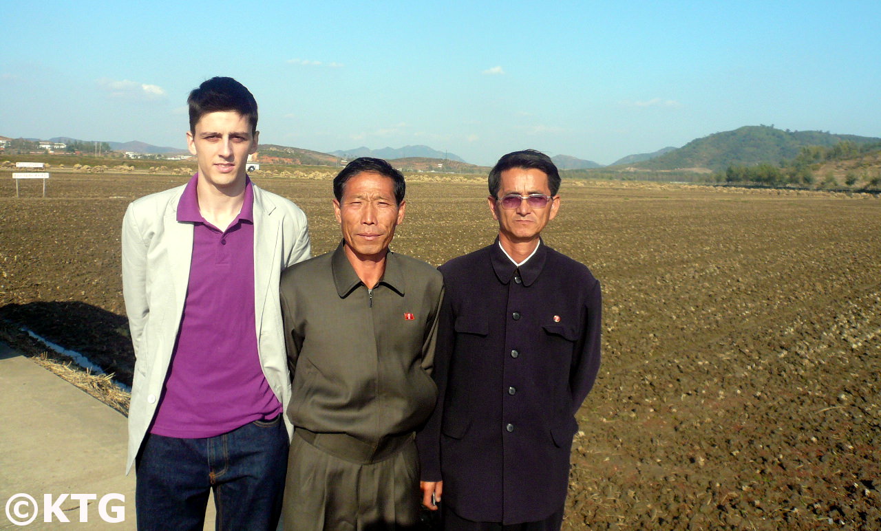 Miembro del equipo KTG posa con los encargados de la granja Chongsan cerca de la ciudad de Nampo en Corea del Norte