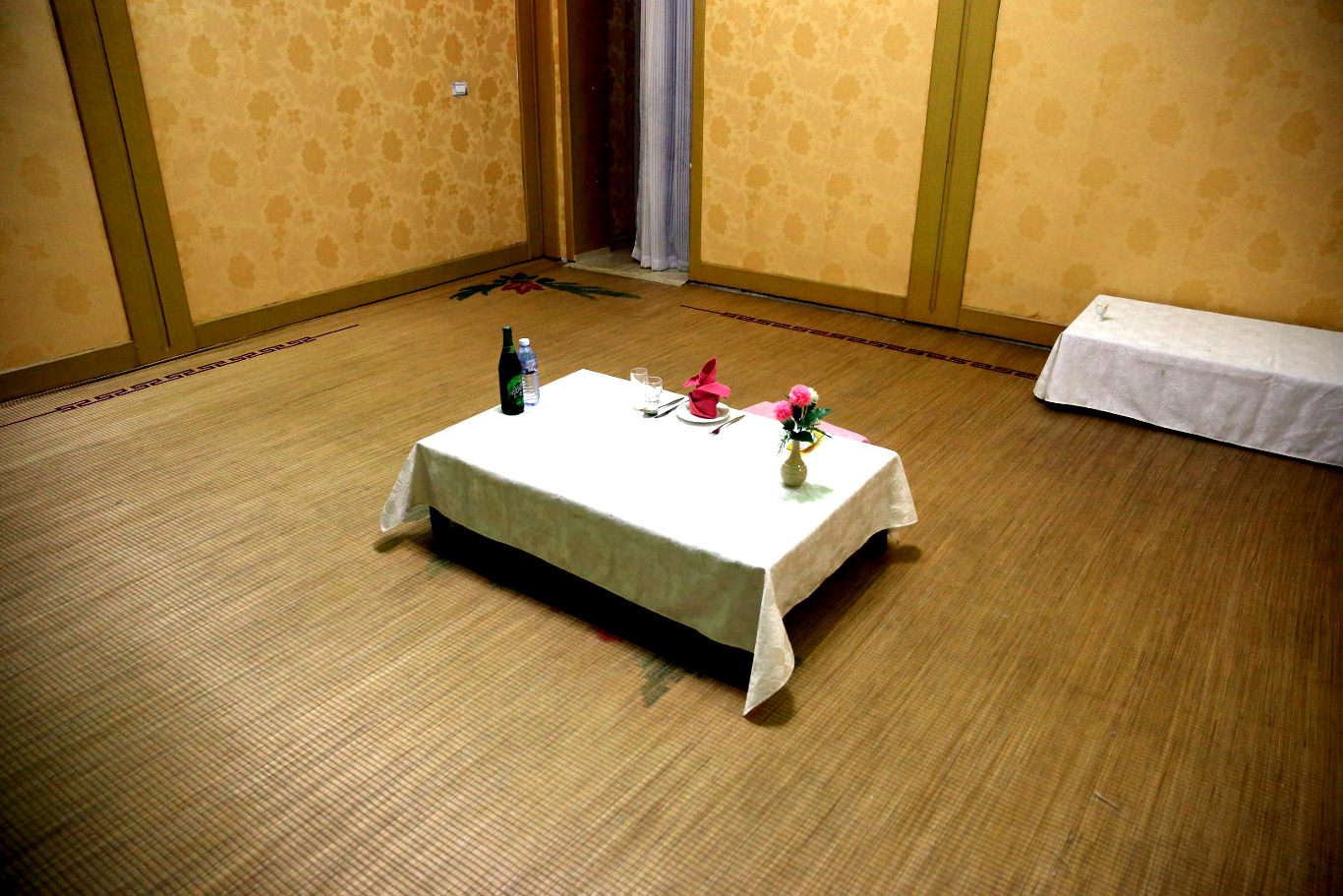 Dinner setting at the Kaesong Folk Hotel in North Korea aka Kaesong Minsok Hotel. We eat and sleep on the floor at this Korean traditional hotel. Trip arranged by KTG Tours