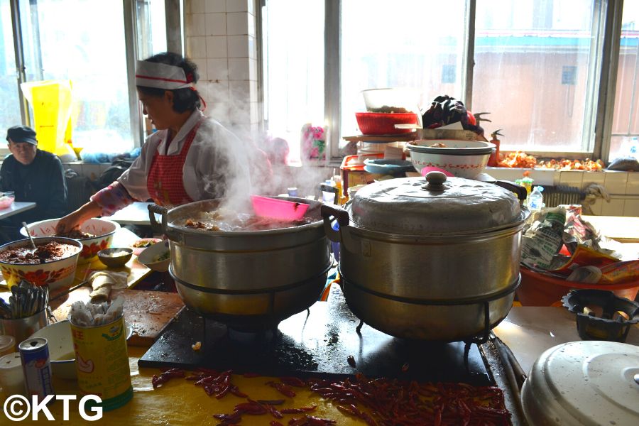 Lady making dog soup in a market in Helong, Yanbian