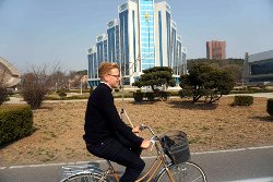 Viajero de KTG Tours en bicicleta por Pyongyang, capital de Corea del Norte