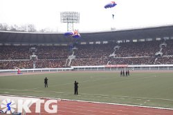 Actuación en paracaídas durante la maratón de Pyongyang en el estadio Kim Il Sung en Corea del Norte (RPDC)