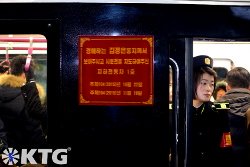 Pyongyang metro staff member. They dress in what looks like navy blue military uniforms