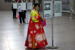 north Korean lady reading the newspaper at the Pyongyang metro in North Korea