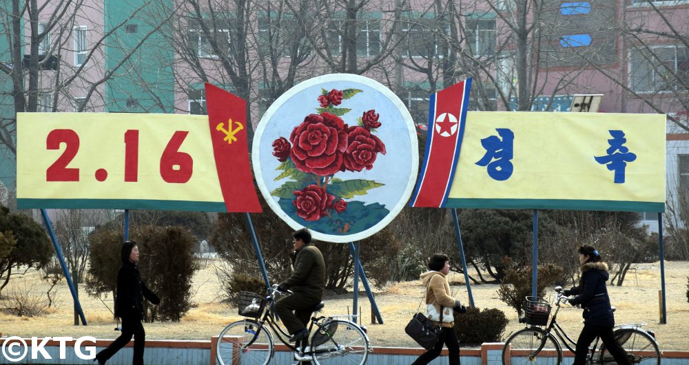 Póster anunciando el Cumpleaños del Líder Kim Jong Il. A cada lado de la fecha (16 de febrero) pueden ver la bandera de Corea del Norte y el emblema del Partido de los Trabajadores de Corea. Viaje a Corea del Norte con KTG