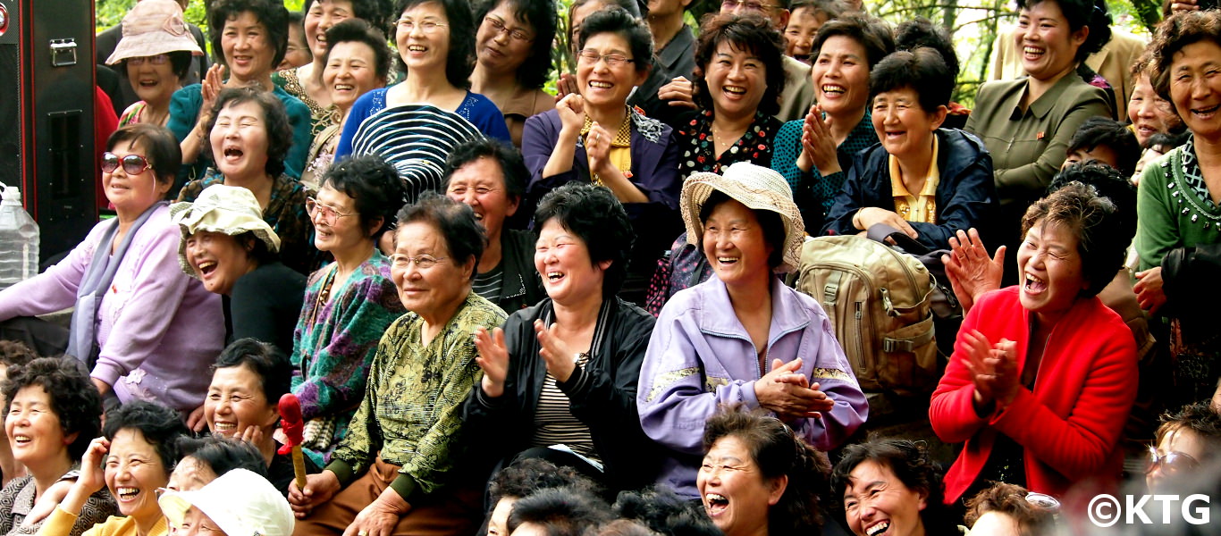 Norcoreanos viendo a una viajera de KTG bailando en un parque en Pyongyang capital de Corea del Norte