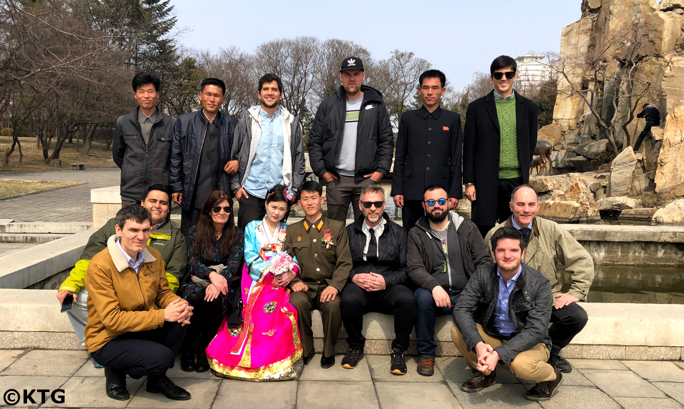 Frisch verheiratetes Paar und eine KTG-Gruppe machen zusammen ein Foto im Fountain Park in Pjöngjang, der Hauptstadt der DVRK, d.h. Nordkorea. Reise arrangiert von KTG Tours