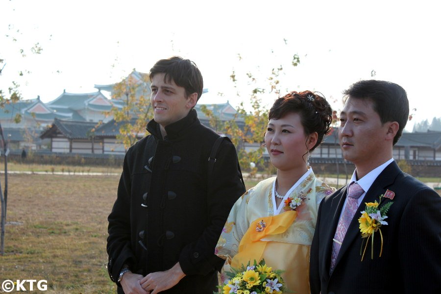 Un couple récemment marié et un membre du personnel de KTG prenant une photo ensemble dans ce qui était autrefois connu sous le nom de mini-Pyongyang à Pyongyang, la capitale de la RPDC, c'est-à-dire la Corée du Nord. Voyage organisé par KTG Tours