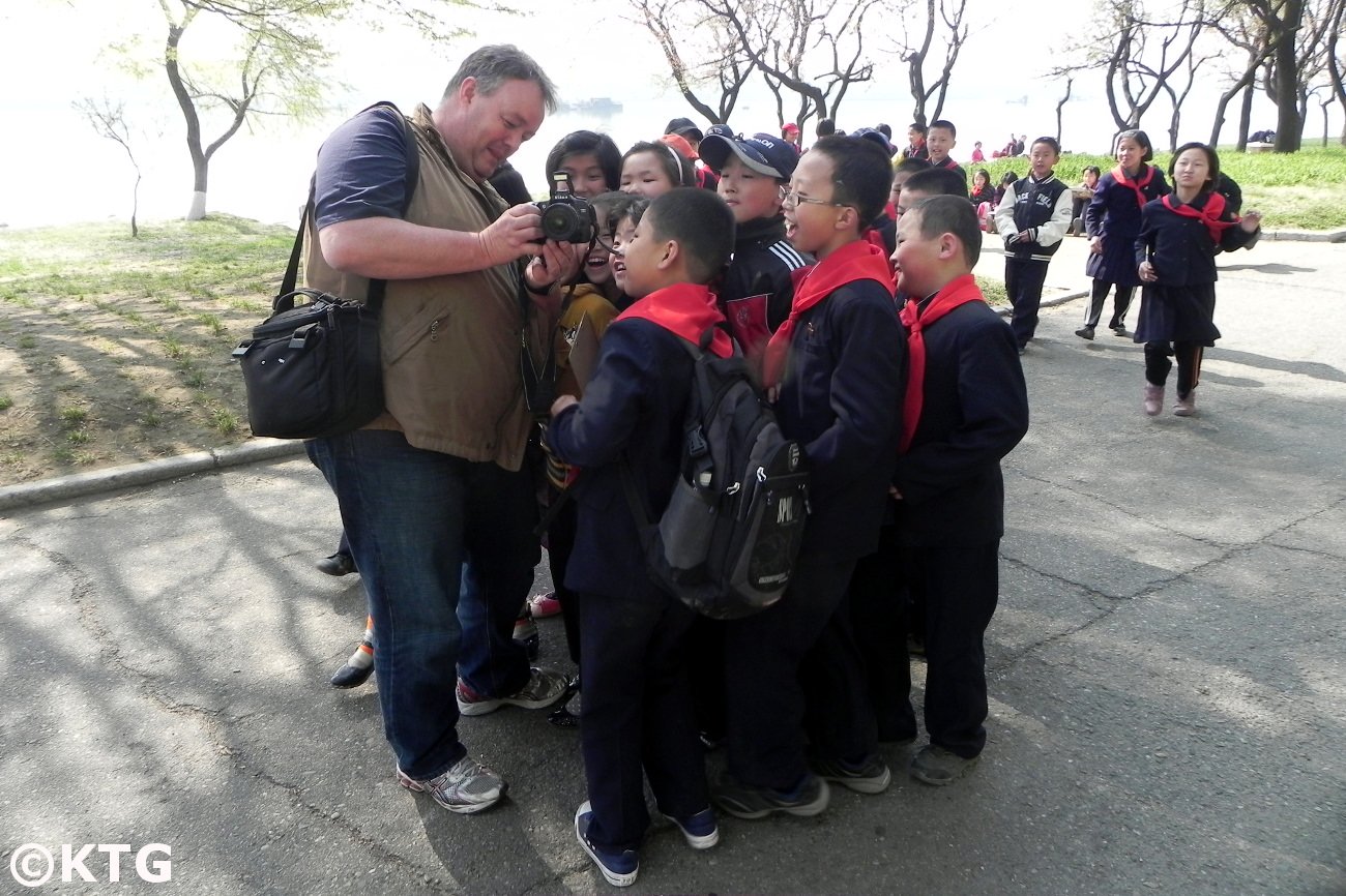 Voyageur de KTG montrant aux enfants nord-coréens une photo qu'il vient de prendre. C'était le long de la rivière Taedong à Pyongyang, la capitale de la RPDC (Corée du Nord). Voyage organisé par KTG Tours
