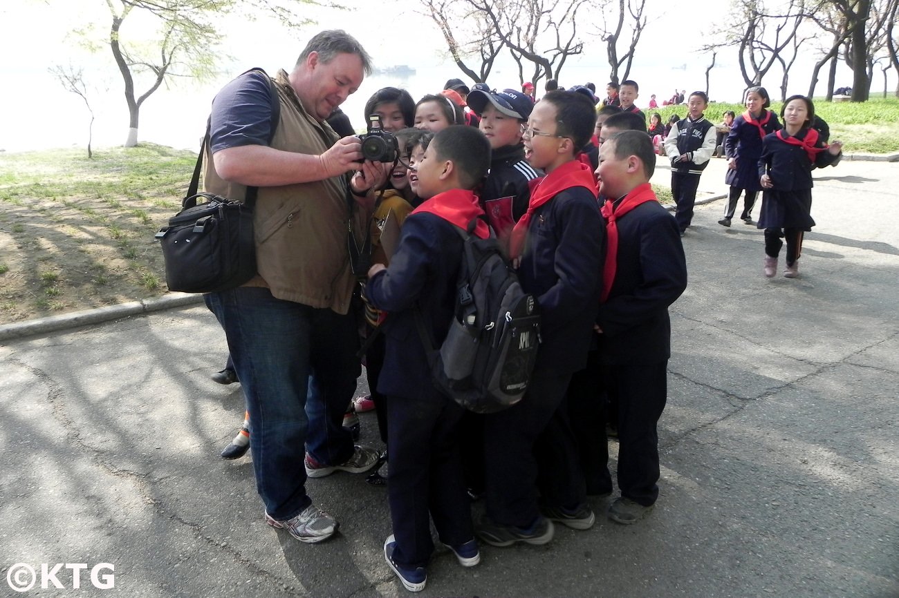 Viajero de KTG mostrando a niños norcoreanos una foto que acaba de tomar. Esto fue junto al río Taedong en Pyongyang, capital de la RPDC (Corea del Norte). Viaje organizado por KTG Tours