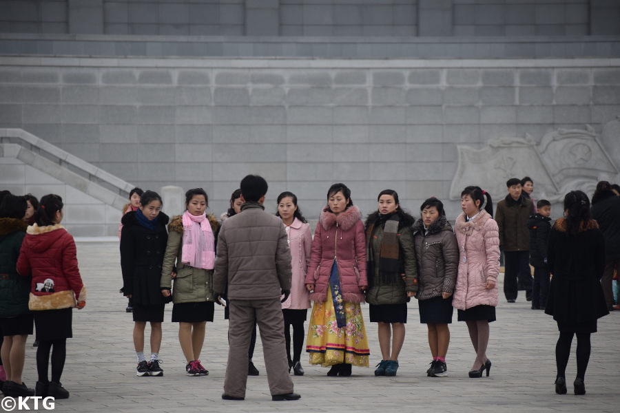 Koreans gathering by the square at the Kumsusan Palace of the Sun. It used to be called the Kumsusan Memorial Palace and before that the Kumsusan Assembly Hall. This is the most sacred place in the DPRK, North Korea. It used to be President Kim Il Sung's Presidential Office and is where the Leaders President Kim Il Sung and Chairman Kim Jong Il lay in state. Picture taken by KTG Tours