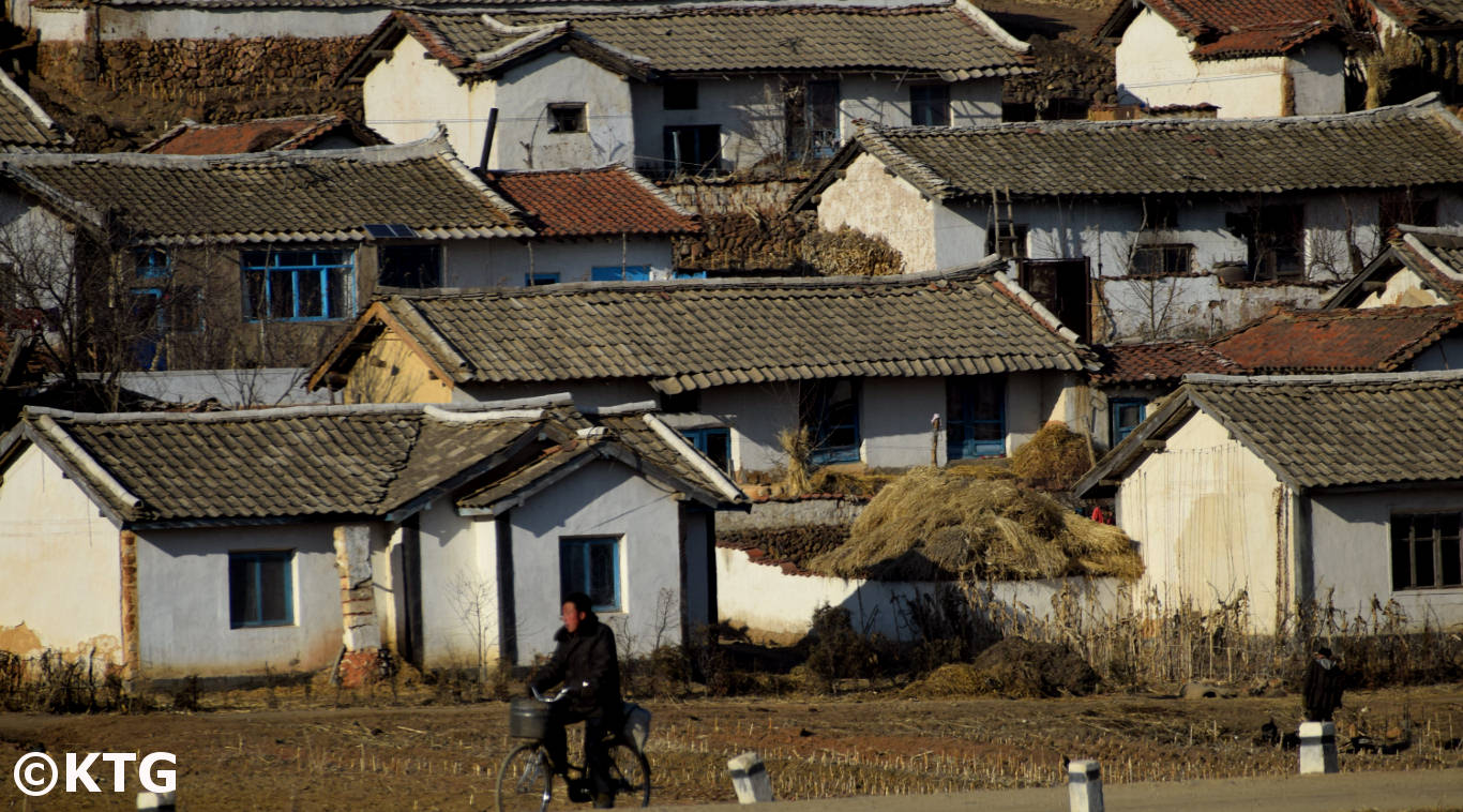 Hombre en bicicleta en el campo en Corea del Norte (República Popular Democrática de Corea). Tour organizado por KTG Travel