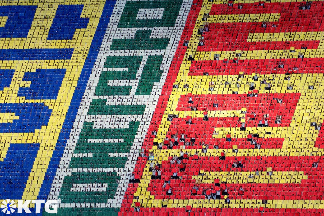The Mass Games in North Korea have a backdrop of 17,000 students. Each student makes a tiny pixel creating gigantic mosaics. Trip arranged by KTG Travel