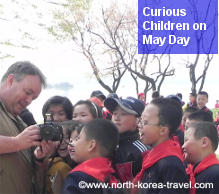 Mei Day Holiday in North Korea. Some curious North Korean children see pictures taken by a traveller