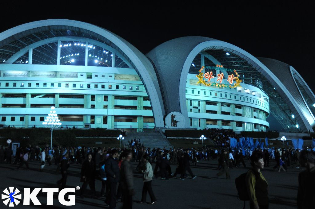 Personas reunidas fuera del estadio Rungrado May Day justo antes de la actuación de los Juegos Masivos, Corea del Norte, RPDC.