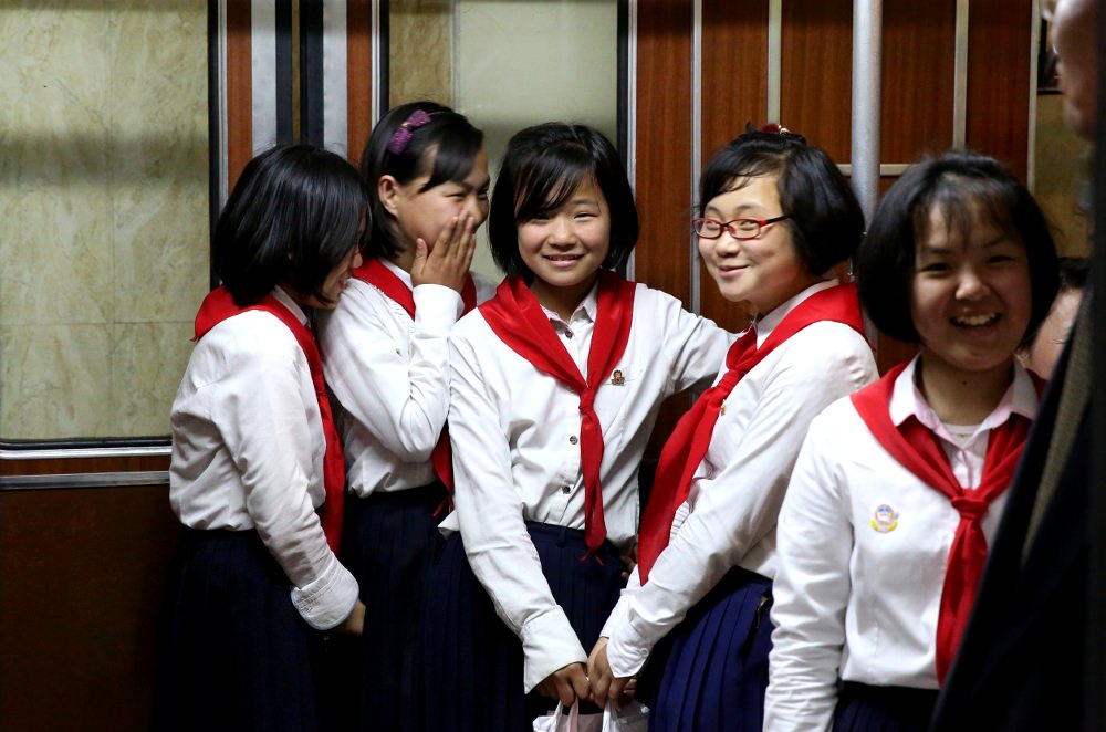 young pioneers at the Pyongyang metro smile at a KTG traveller.