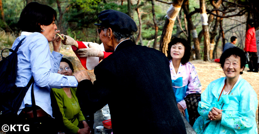 North Koreans dancing in Moran Park with a traveller from KTG during President Kim Il Sung's birthday one of the DPRK's biggest holidays