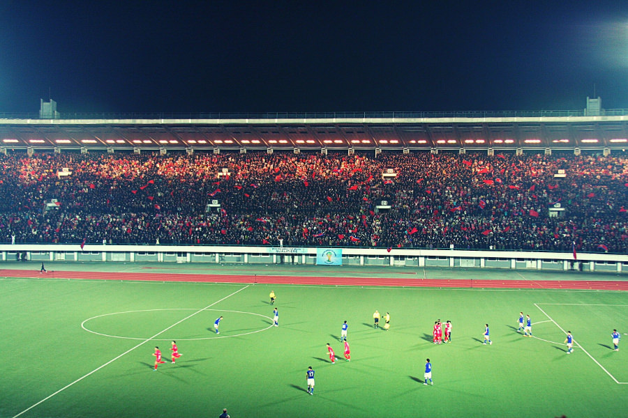 L'équipe nationale de football de la Corée du Nord célèbre le but contre le Japon lors d'un match de qualification pour la Coupe du monde à Kim Il Sung Square à Pyongyang, capitale de la Corée du Nord. Voyage organisé par KTG Tours.