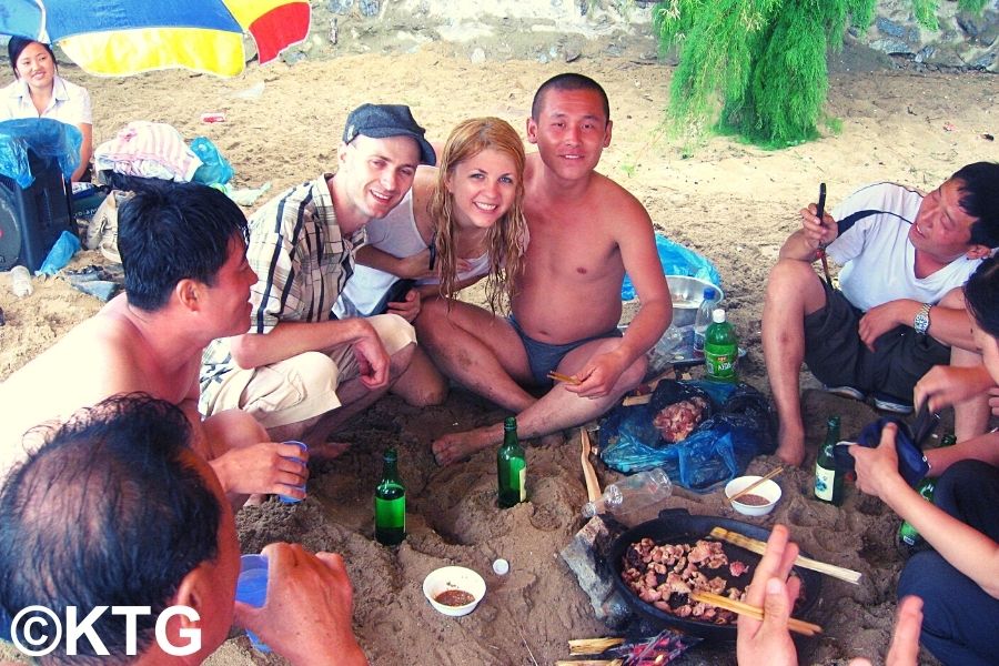 Des voyageurs prennent des verres avec des habitants à la plage de Majon à Hamhung, sur la côte est de la Corée du Nord, en RPDC.