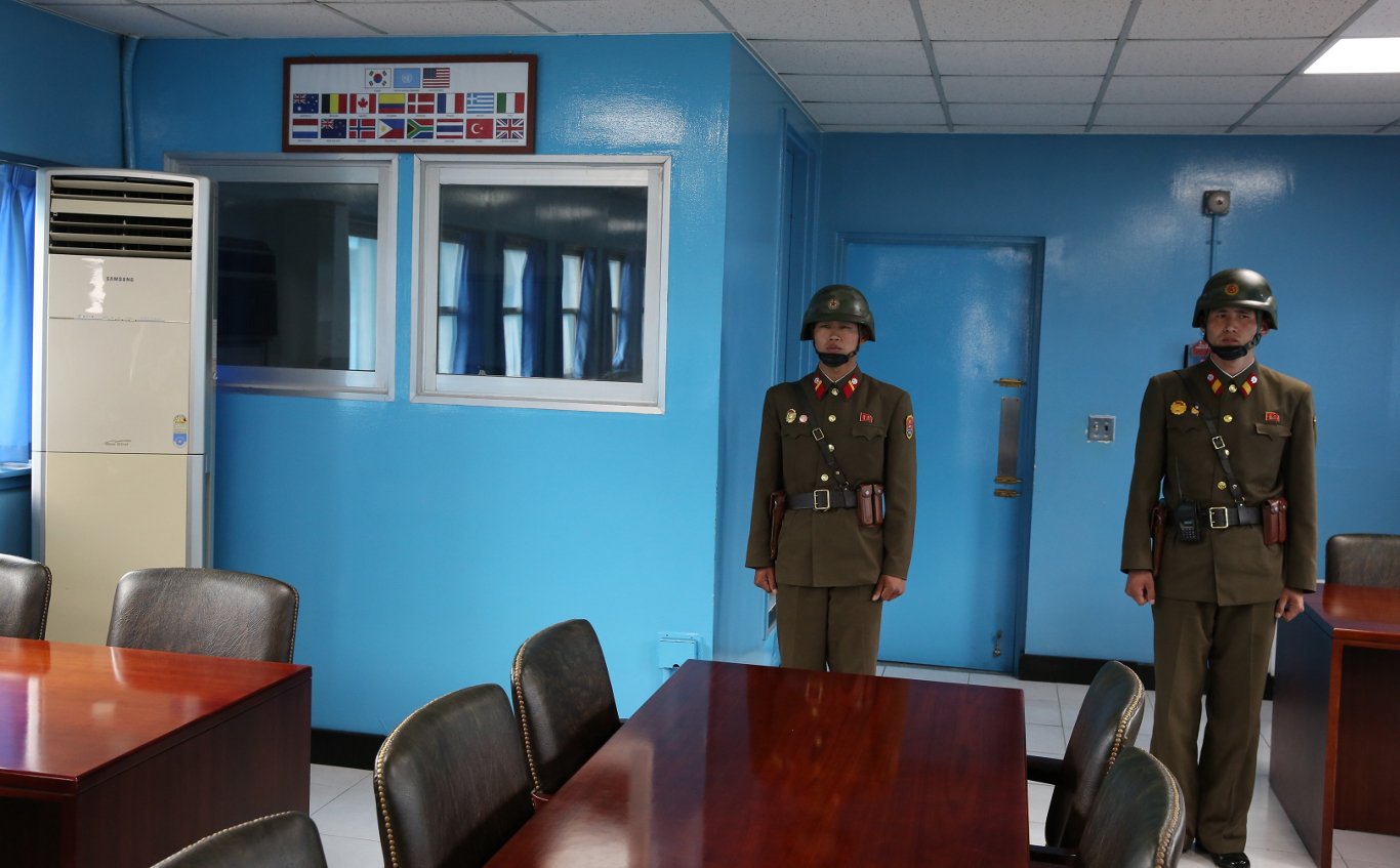 North Korean soldiers standing on the door of the blue negotiations room that leads to South Korea. It is strictly forbidden to go behind them. Trip arranged by KTG Tours