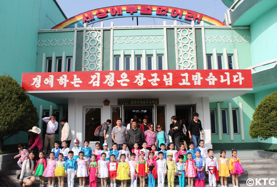 Chinese tourists pose with children at the Ponbu kindergarten in Sinuiju, North Pyongan Province, North Korea (DPRK). Tour arranged by KTG Tours