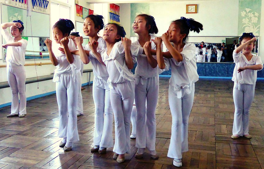 Des élèves nord-coréens dansent à l'école primaire Dongsuk de la ville de Pyongsong faisant la queue le matin avant les cours. C'est dans la province de Pyongan du Sud en Corée du Nord, en RPDC. Photo prise par KTG Tours