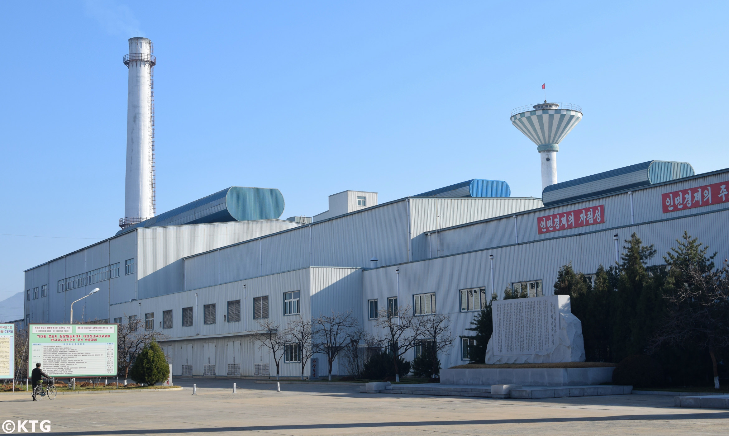 Entrada a la fábrica de producción de vidrios cerca de Nampo en Corea del Norte. Foto viajes KTG