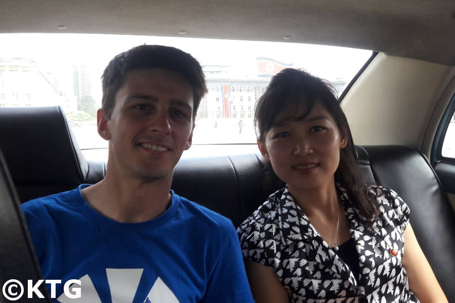 KTG staff member taking a taxi with former North Korean guide, Kim Song Sim, in Kim Il Sung Square, the heart of Pyongyang, capital of North Korea (DPRK