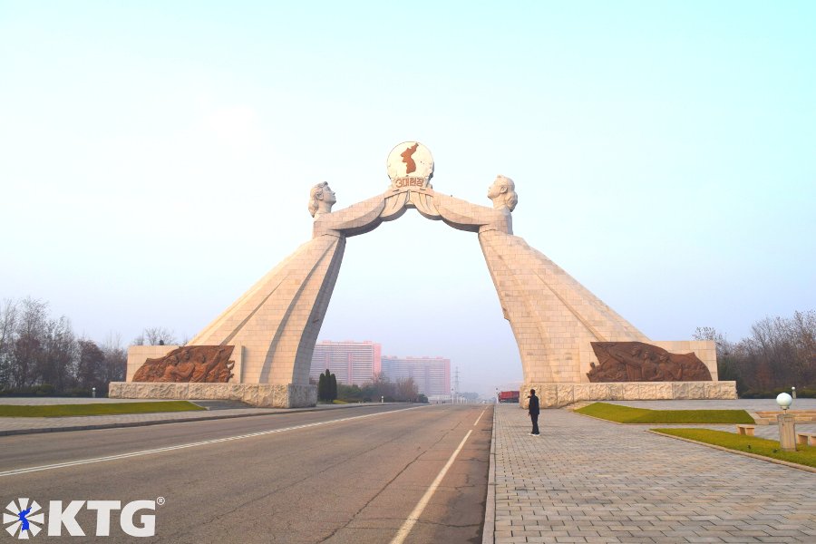 KTG traveller taking a photo of the arch of reunification in Pyongyang, North Korea, DPRK. The Monument to Three Charters for National Reunification symbolises the reunification of Korea and was built in 2001.