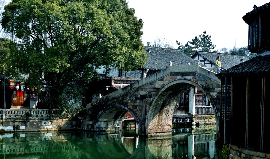 Puente de piedra sobre un canal en el pueblo antiguo de canales de Xitang en la provincia de Zhejiang en el sur de China y cerca de la ciudad de Shanghai